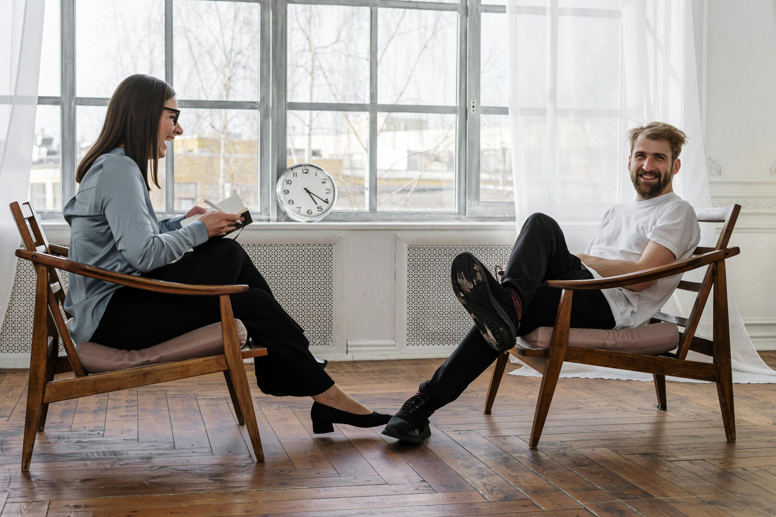 Home Counselor and client in a positive therapy session in a well-lit room.